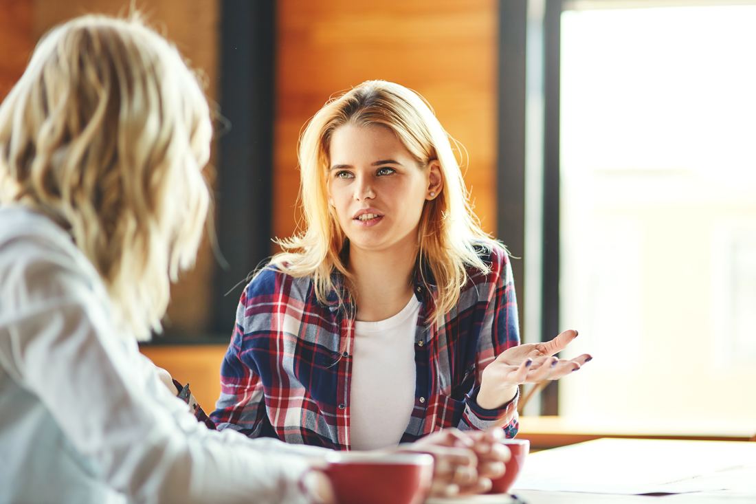 Two women in earnest conversation over coffee