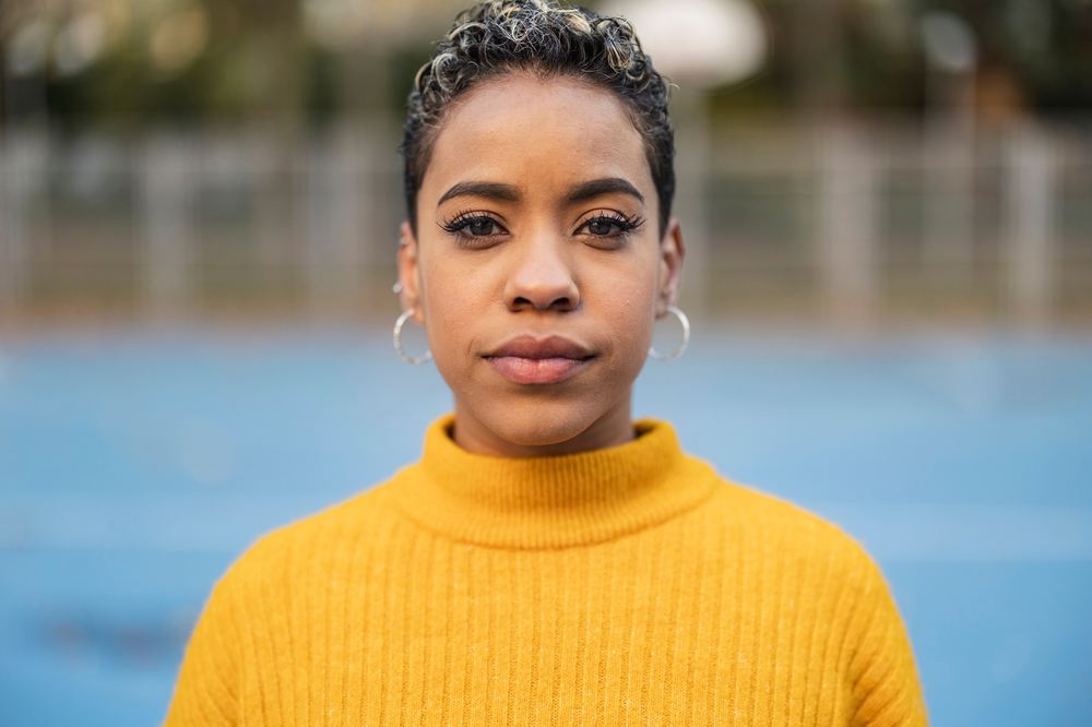 A young woman meeting the camera with calm, steady strength